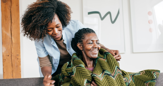 Caregiver helping a senior in a Canadian home environment.