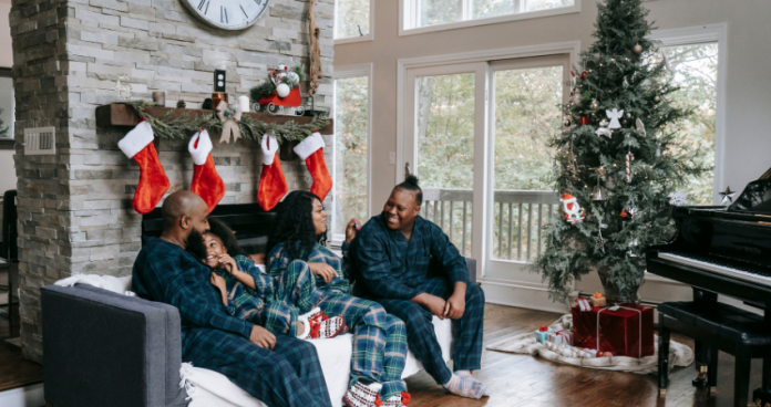 Family celebrating Christmas outdoors with snowy mountains in the background.