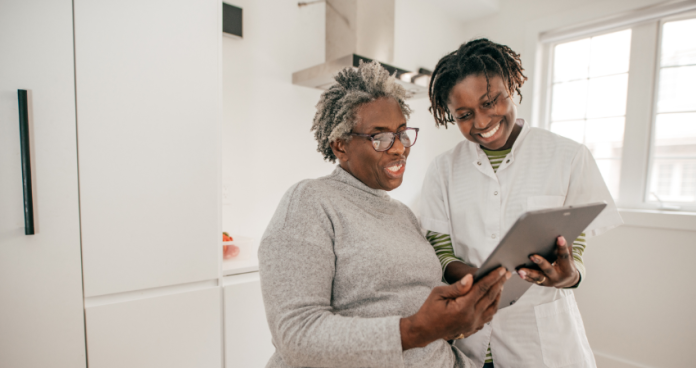 Caregiver supporting an elderly patient in a European home environment.