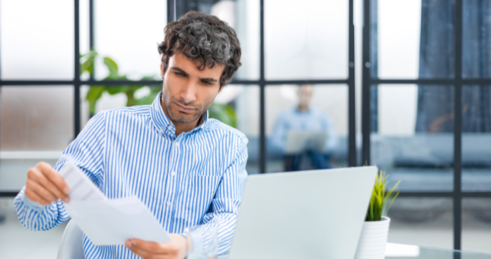 Individual composing a cover letter on a laptop with a world map in the background, representing international job search.