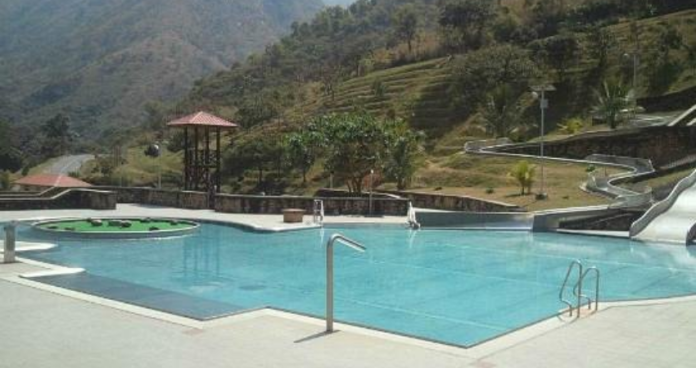 Obudu Mountain Resort featuring cable cars gliding over lush green hills with a backdrop of misty mountain peaks.