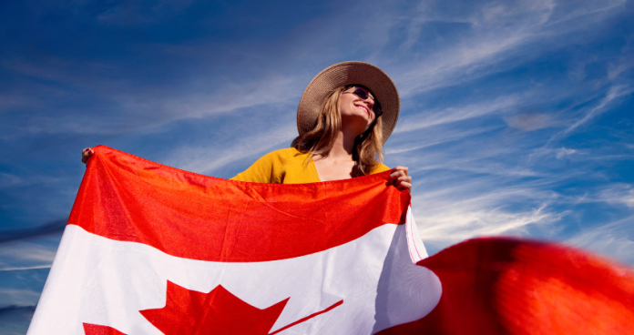 First-time traveler arriving in Canada at the airport with a passport and Canadian flag.